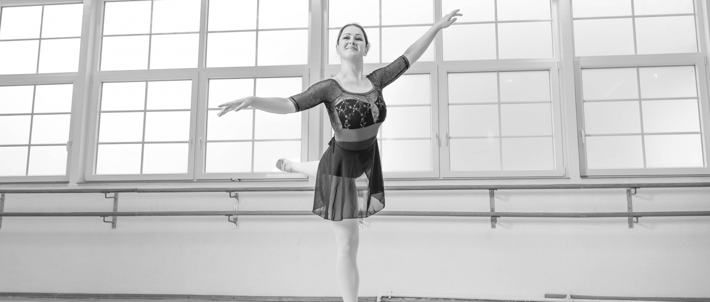 Erwachsene Tänzerin in arabesque-Pose – Balance und Eleganz im Ballettstudio Nett & Friends.