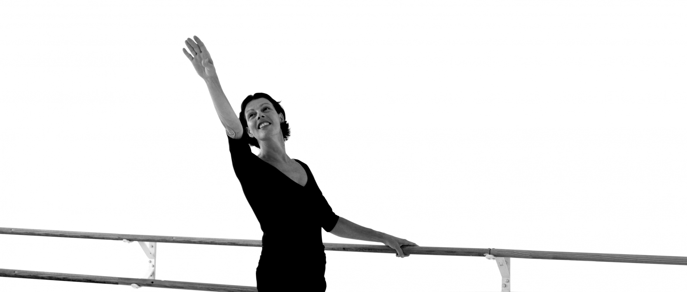 Balletttänzerin im klassischen Training – aufrechter Stand und präzise Armhaltung im Ballettsaal Köln.
