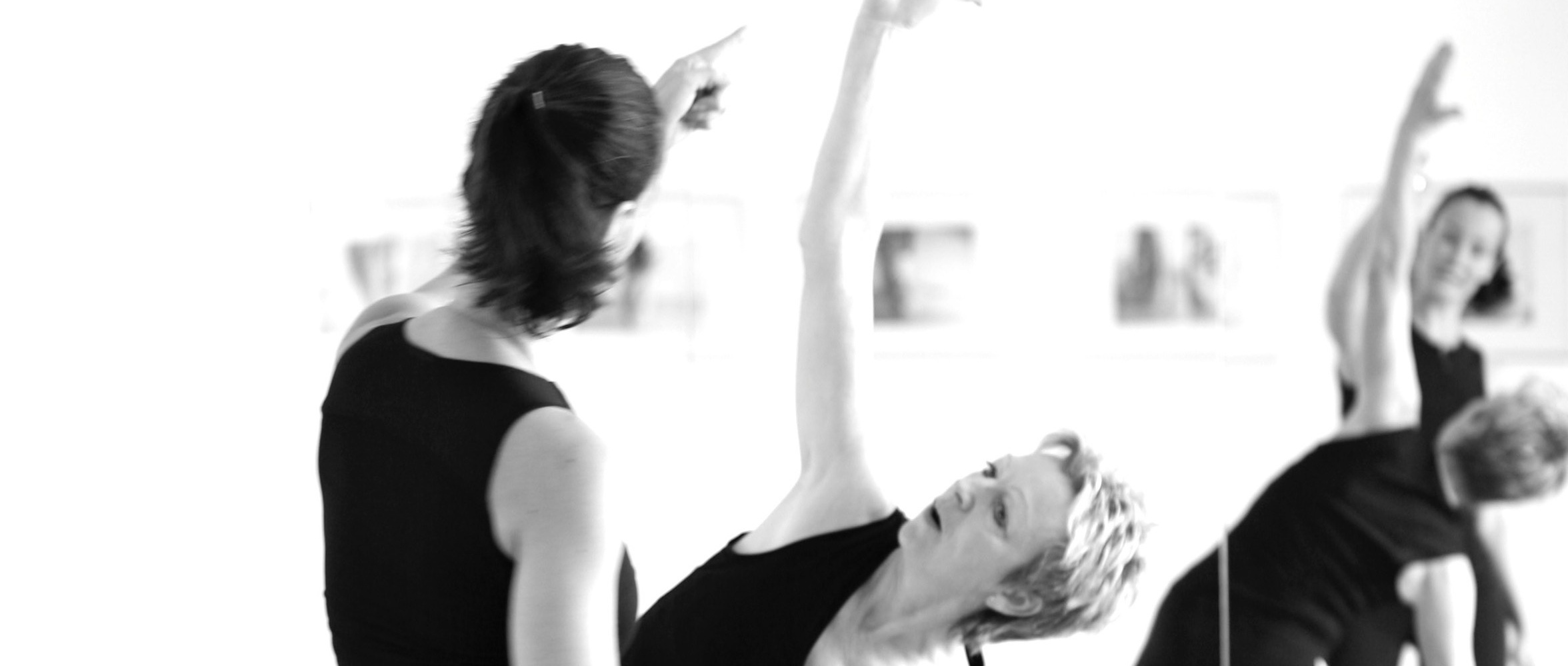 Yogalehrerin korrigiert Haltung einer Teilnehmerin im Yoga-Kurs Siegburg