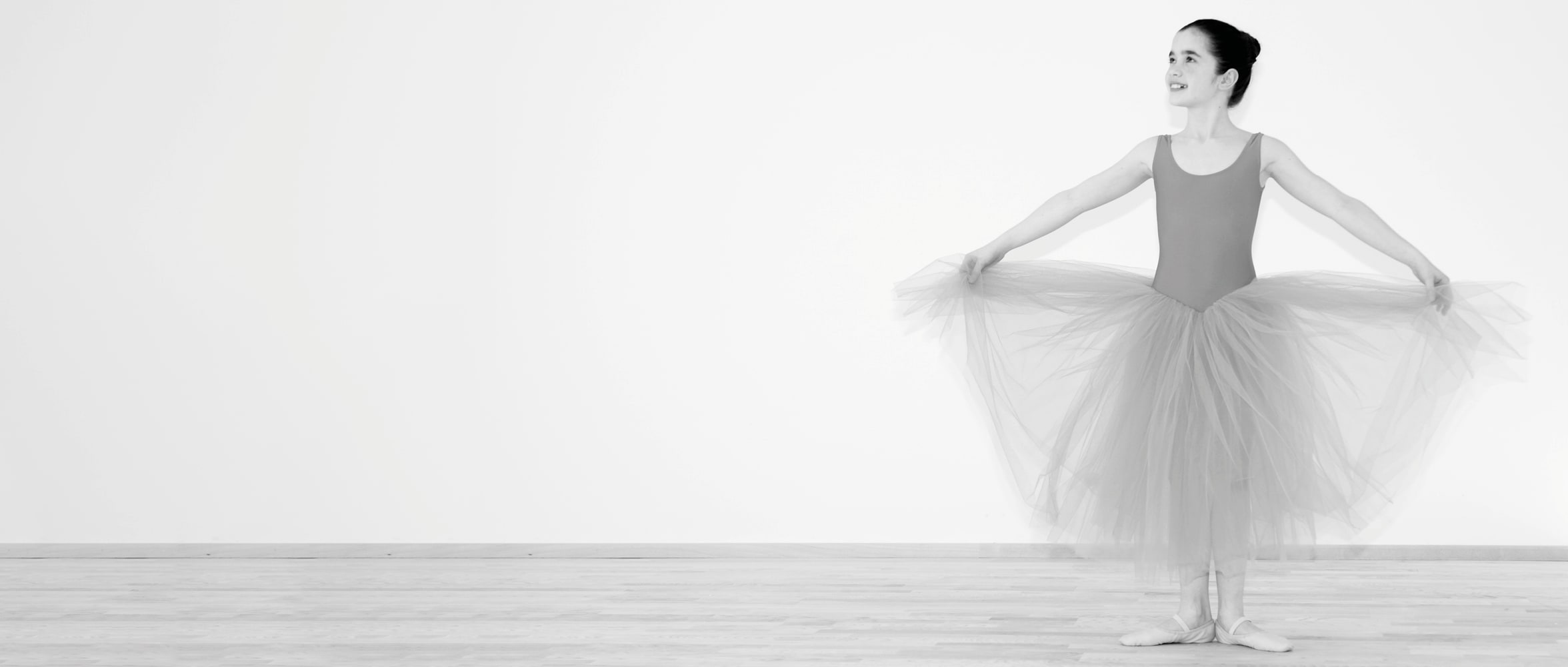 Ballerina mit langem Tüllrock hält den Rock elegant im Tanzstudio Nett & Friends