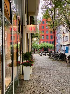 Tanzschuleingang mit Blick entlang des Brigittengässchens auf das rote Haus am Ende mit dem Denkmal von Tünnes & Schäl.